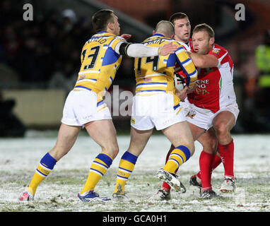 Il Jamie Thackray dei Celtic Crusaders (a destra) è affrontato da Leeds Rhinos' Matt Diskin e Kevin Sinfield (a sinistra) durante la partita Engage Super League presso l'ippodromo di Wrexham. Foto Stock