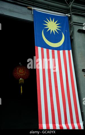 Grande bandiera della Malesia si blocca nel portale con rosso lanterna cinese nel retro Georgetown Penang Foto Stock