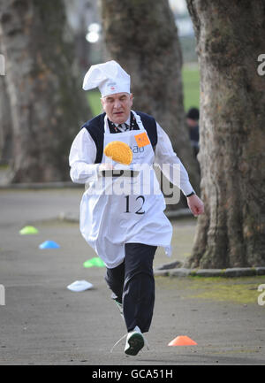 Stephen Pound MP partecipa all'annuale Parliament Pancake Race di Westminster, Londra, insieme ad altri parlamentari, giornalisti e membri della Camera dei Lord, per raccogliere fondi per la beneficenza Rehab e per sensibilizzare il pubblico sul suo lavoro per le persone con disabilità. Foto Stock