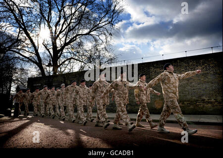 I membri della regina Yeomanry, il Royal Mercian e Lancastrian Yeomanry, Royal Signals e Royal Electrical and Mechanical Engineers marciano attraverso le porte della Clarence House prima di essere presentati con le Medaglie di Servizio Afghanistan dal Principe del Galles, nel centro di Londra. Foto Stock