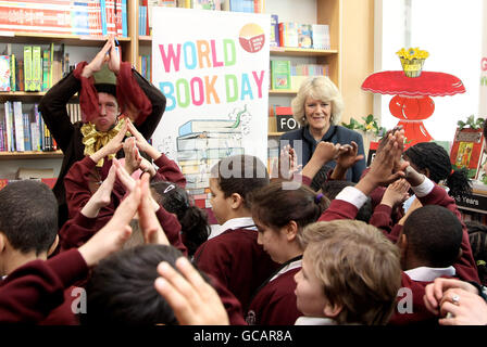 La Duchessa di Cornovaglia guarda sopra mentre i bambini della Avondale Park School sono intrattenuti da Tom Walker 'Mad Hatter' durante una visita ad un Mad Hatter's Tea Party a Foyles, Westfield a Londra, per celebrare la Giornata Mondiale del Libro Foto Stock