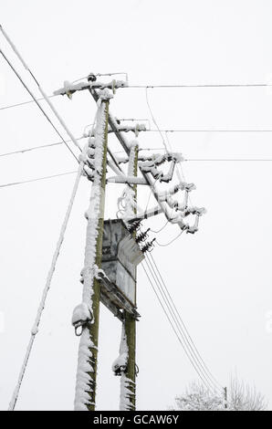 La distribuzione di energia elettrica cavi e trasformatore coperto di neve. Foto Stock