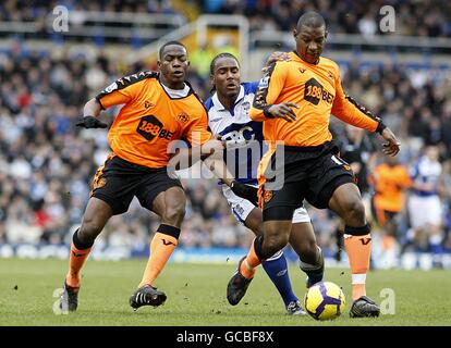 Maynor Figueroa di Wigan Athletic (a sinistra) tiene fuori il Cameron di Birmingham City Jerome (al centro) come il suo compagno di squadra Titus Bramble (a destra) corre con la sfera Foto Stock