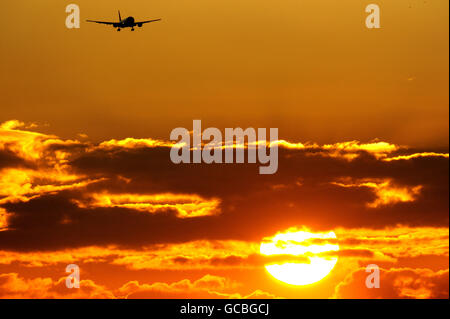 Un aereo arriva all'aeroporto di Heathrow quando il sole sorge su Londra. Londra Heathrow è uno degli aeroporti internazionali più trafficati al mondo. Oltre 67 milioni di passeggeri viaggiano ogni anno attraverso l'aeroporto su servizi offerti da 90 compagnie aeree che viaggiano verso oltre 180 destinazioni in oltre 90 paesi. Foto Stock