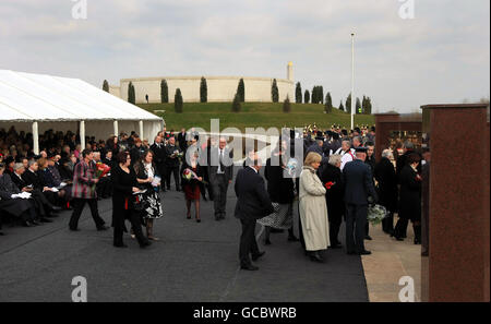 I membri della famiglia del personale di servizio caduto si avvicinano al muro commemorativo di Basra al National Memorial Arboretum vicino Alrewas nello Staffordshire, per posare i fiori durante un servizio per ridedicare il muro dopo che è stato spostato da Basra, Iraq. Foto Stock