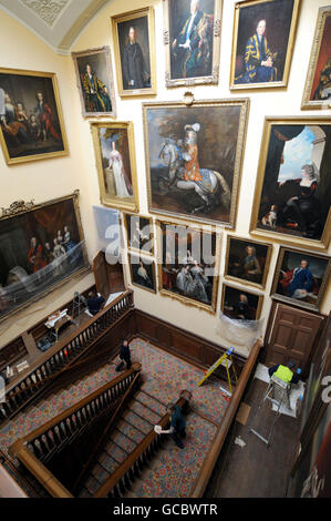 Il personale della Chatsworth House prepara la maestosa Casa per la sua apertura al pubblico questa Domenica, mentre puliscono la scala intorno ai ritratti di famiglia del Duca di Devonshire. Il Parlamento è pronto per l'apertura al pubblico questa domenica. Foto Stock