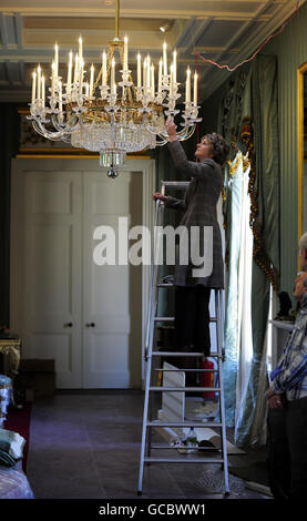 La Duchessa del Devonshire regola un lampadario a Chatsworth House Derbyshire. L'Assemblea è pronta ad aprire al pubblico questa domenica. Ogni lampadario impiega due giorni per appendere. Foto Stock