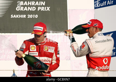 Lewis Hamilton della McLaren (a destra) festeggia il suo terzo posto con il vincitore Fernando Alonso durante il Gran Premio del Golfo Air Bahrain al circuito Internazionale del Bahrain a Sakhir, Bahrain. Foto Stock