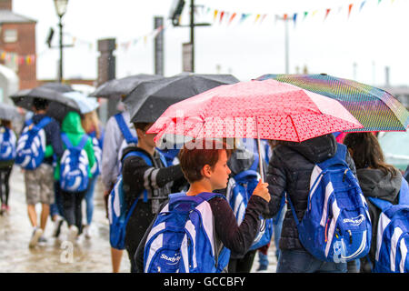 Pioggia pesante, Liverpool. Regno Unito: Meteo 09-luglio-2016. Piogge torrenziali acquazzoni benvenuti a centinaia di studenti stranieri come fanno visita l'Albert Dock di Liverpool. Con temperature al di sotto della media stagionale & cool docce pesanti al di sopra della regione, il meteo non mostra alcun segno di locazione per i visitatori. Credito: Cernan Elias/Alamy Live News Foto Stock