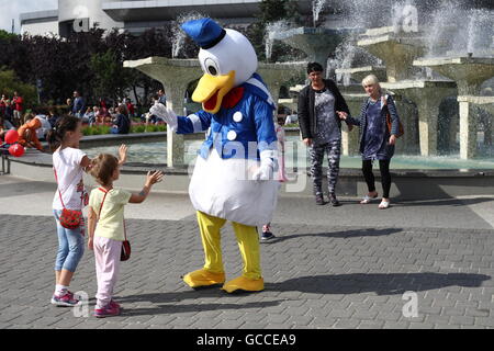 Gdynia, Polonia 9th, Luglio 2016 Dopo pochi freddi e piovosi giorni, le persone godono di soleggiato e abbastanza caldo a Gdynia, sabato 9 luglio. Donald Duck mascotte accogliente bambino è visto nella parte anteriore della fontana a Gdynia in Piazza Kosciuszko Credito: Michal Fludra/Alamy Live News Foto Stock