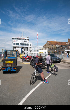 YARMOUTH HARBOUR ISLE OF WIGHT - i ciclisti in attesa di salire a bordo di un rotolo sul roll off traghetto ormeggiato sul lungomare Foto Stock