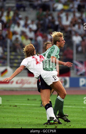 Calcio - Coppa del mondo FIFA Italia 1990 - Semifinale - Germania Ovest / Inghilterra - Stadio delle Alpi. Mark Wright (l) dell'Inghilterra e Jurgen Klinsmann (r) della Germania occidentale si sfidano per la palla Foto Stock