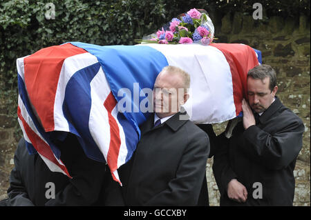 I Pallbearers portano la Bandiera dell'Unione Britannica e la bandiera francese drappeggiato di Andree Peel, che servì nella resistenza francese durante la guerra alla chiesa di All Saints a Long Ashton, vicino Bristol. Foto Stock