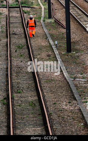 Un ingegnere ferroviario di rete cammina lungo la pista vicino alla stazione ferroviaria di Cambridge City nel centro della città. Foto Stock