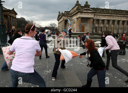 La gente che ha una lotta del cuscino al Mound a Edinburgh mentre prende parte alla Giornata internazionale di lotta del cuscino. Foto Stock