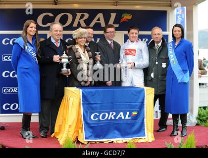 Jockey Barry Geraghty (terza a destra) Celebra la vittoria della Coral Cup su Spirit River con l'allenatore Nicky Henderson (centro) e il proprietario Michael Buckley (seconda a sinistra) Foto Stock