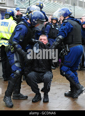 Un sostenitore della Lega della Difesa inglese è trattenuto dagli agenti di polizia durante una protesta nel centro di Bolton. Foto Stock