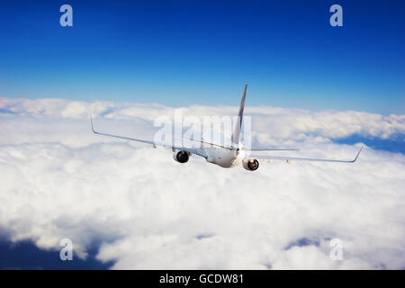 Aviogetti piano volare sopra le nuvole in luce del giorno Foto Stock