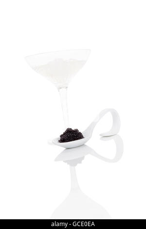 Delizioso caviale nero sul cucchiaio con vodka con ghiaccio isolato su sfondo bianco. Lusso squisito buongustai. Foto Stock