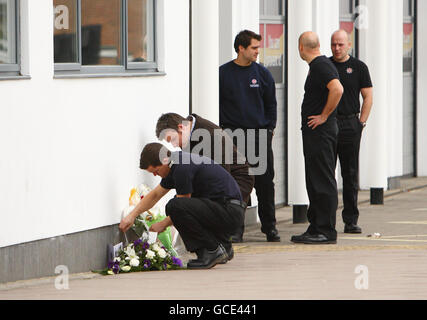 Un vigili del fuoco depone i fiori fuori dalla stazione dei vigili del fuoco di St Marys a Southampton dopo che i vigili del fuoco Alan Bannon e James Shears, con sede nella stazione, sono stati uccisi durante un incendio a Shirley Towers nella zona di Shirley della città durante la notte. Foto Stock