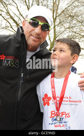 Sir Ian Botham a Hyde Park, Londra con Joe Smale, 12 anni, di Chiswick, che è in cura per la leucemia per la seconda volta, dopo aver completato la tappa finale della sua 10 giorni a livello nazionale Forget-Me-Not Walk in aiuto della Leukemia Research. Foto Stock