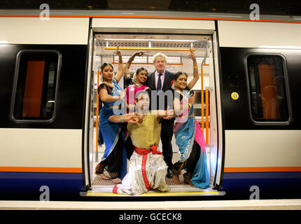 Il sindaco di Londra Boris Johnson si pone con un gruppo di ballerini indiani a una fotocellula per segnare l'apertura della nuova rotta di Londra Overground, a Dalston Junction Station, a Hackney, a est di Londra. Foto Stock