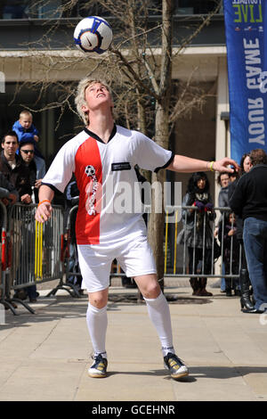 Il campione del mondo di calcio Freestyle John Farnworth intrattiene la folla durante L'evento di lancio di Grass Roots Football Live Foto Stock