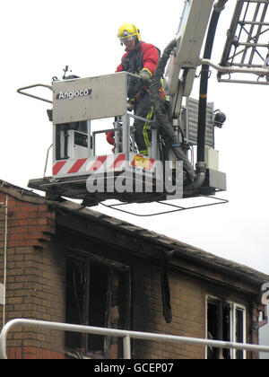 I servizi di emergenza utilizzano una piattaforma aerea a scala (ALP) per ispezionare la scena in seguito a un incendio di una casa a Buxton, Derbyshire, il venerdì sera in cui sono morti due bambini. Foto Stock