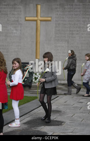 Meadhbh, 9, (al centro), figlia di Taoiseach Brian Cowen, si prepara a posare un giglio alle tombe dei leader irelands dell'insurrezione del 1916, durante l'annuale Fianna Fail Easter Rising Commemoration a Arbour Hill, Dublino. Foto Stock