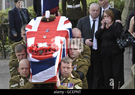 La famiglia e gli amici seguono la bara drappeggiato con bandiera dell'Unione di Fusilier Jonathan Burgess, 20, così come viene portata dalla Chiesa Cattedrale di San Giuseppe, Swansea, dopo i suoi funerali. Foto Stock