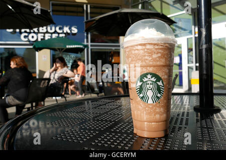 Un lato della gente beve caffè Starbucks sulla giornata di sole, concentrarsi su ghiaccio moka frappuccino Foto Stock