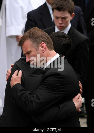 Il fratello di Gerry Ryan, Mick (a destra), abbraccia, figlio di suo nipote fratello, Rex, in seguito al funerale di Ryan presso la Chiesa di San Giovanni Battista a Clontarf, Dublino. Foto Stock