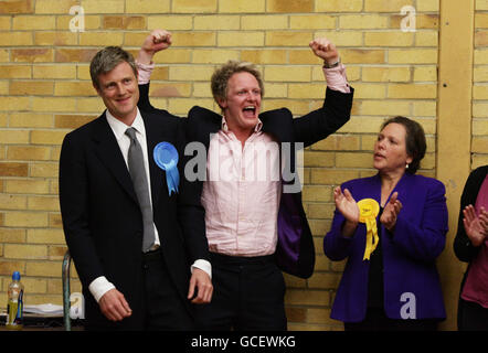 Zac Goldsmith (a sinistra) celebra la vittoria del posto per Richmond Park con il suo agente elettorale David Newman, come sconfitto candidato liberal-democratico Susan Kramer guarda sopra al Richmond upon Thames College. Foto Stock