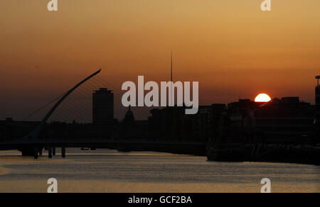 Il sole tramonta sul fiume Liffe a Dublino, mentre una nube di cenere proveniente da un vulcano islandese ha messo a terra tutti i voli di emergenza oltre alla Gran Bretagna, lasciando migliaia di passeggeri bloccati. Foto Stock