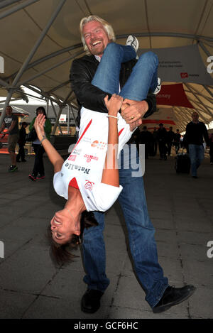 Sir Richard Branson dà un ascensore a Natalie Imbruglia, la cantante-attrice australiana, davanti alla maratona della Vergine di Londra, presso l'Excel Centre nella parte est di Londra. Foto Stock