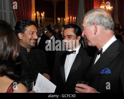 Il Principe del Galles parla con gli attori Nitin Ganatra e Sanjeev Bhaskar (centro), prima di una cena per il British Asian Trust di cui è presidente, negli appartamenti di Stato al St James's Palace nel centro di Londra, questa sera. Foto Stock