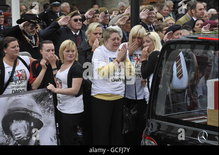 Cheryl Edgar (fronte, seconda a sinistra)), fidanzata di Sapper Daryn Roy, 28, e i pianori guardano come audizioni che contengono le barbine di Sapper Daryn Roy, Lance Corporal Barry Buxton e Corporal Harvey Holmes passano attraverso la città di Wootton Bassett dopo il loro rimpatrio a RAF Lyneham in Wiltshire. Foto Stock