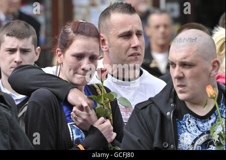 I Mourners guardano come le audizioni che contengono le barene di Sapper Daryn Roy, del corporale di Lance Barry Buxton e del corporale Harvey Holmes passano attraverso la città di Wootton Bassett dopo il loro rimpatrio a RAF Lyneham in Wiltshire. Foto Stock