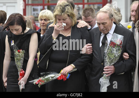 I Mourners guardano come le audizioni che contengono le barene di Sapper Daryn Roy, del corporale di Lance Barry Buxton e del corporale Harvey Holmes passano attraverso la città di Wootton Bassett dopo il loro rimpatrio a RAF Lyneham in Wiltshire. Foto Stock