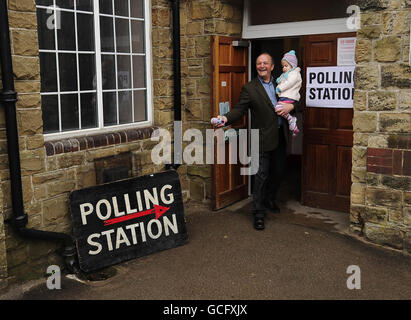 Un elettore che porta un bambino lascia la stazione di polling alla Bent Green Methodist Church Hall, Sheffield, dopo aver votato oggi alle elezioni generali. Foto Stock