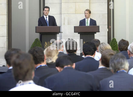 Il Cancelliere dello scacchiere George Osborne (a sinistra) e il Segretario principale del Tesoro David Laws MP tengono una conferenza stampa nel giardino del Tesoro HM, Londra. Foto Stock