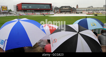 La pioggia ritarda l'inizio del Day 3 Inghilterra contro Bangladesh A Old Trafford come i tifosi prendere riparo sotto ombrelli Foto Stock