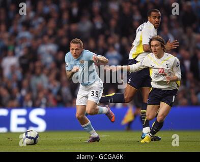 Tom Huddlestone di Tottenham Hotspur (al centro) guarda il suo compagno di squadra Luka Modric (a destra) battaglia Craig Bellamy di Manchester City (a sinistra) al pallone. Foto Stock