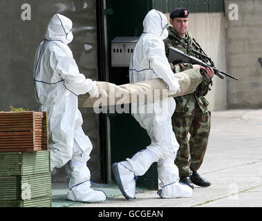 I membri del team forense di Garda e dell'esercito per lo smaltimento delle bombe nel sito dove sono stati scoperti due lanciarazzi caricati, un fucile d'assalto e 9 kg di cocaina nascosti in un magazzino al largo di una strada principale nei pressi di Clane, Co Kildare. Foto Stock