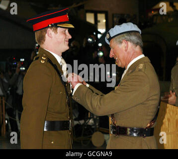 Il principe Harry riceve le sue ali volanti da suo padre, il principe del Galles, durante una cerimonia di laurea da un corso avanzato di addestramento dell'elicottero al museo del Wallop medio dell'esercito a Stockbridge, Hampshire. Foto Stock