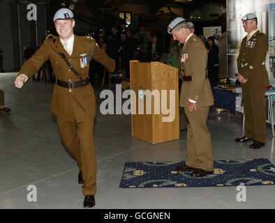 Il principe britannico Harry, a sinistra, si arcate fuori dopo aver ricevuto le ali del suo pilota dell'elicottero da suo padre, il principe Charles, al centro dell'aviazione dell'esercito a Wallop di mezzo, Inghilterra, venerdì 7 maggio 2010. L'esercito britannico ha confermato che Harry deve addestrarsi come pilota dell'elicottero di attacco di Apache. Foto Stock