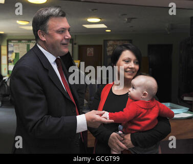 Baby Pheobe Everitt guarda l'ex segretario per bambini ed Balls mentre parla con sua madre, Joanne Everitt, durante una visita ad un gruppo di gioco pre-scuola presso la chiesa di St Gabriel, Pitsea, Essex. Foto Stock