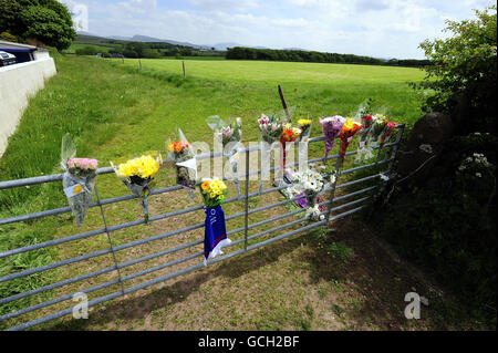 I tributi floreali sono lasciati ad un cancello al campo dove l'agricoltore Garry Purdham, 31, è stato ucciso da Derrick Bird durante il rampage di tiro in Cumbria. Foto Stock