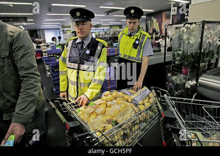 I membri del Gardai proteggono le patate israeliane, dopo che i membri del movimento irlandese contro la guerra hanno cercato di rimuoverle dagli scaffali di Marks e Spencer a Dublino questo pomeriggio per protestare contro il blocco di Gaza. Foto Stock