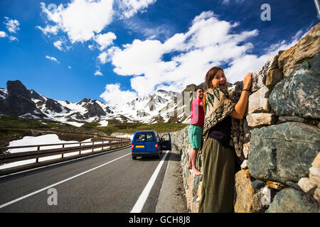 Una coppia che tiene su Una parete di roccia lungo il Passo del Gran San Bernardo, uno dei più antichi passi attraverso le Alpi occidentali, passando attraverso l'Italia ... Foto Stock